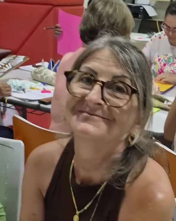 Aluna 50+ sorrindo durante a aula sobre autoconfiança