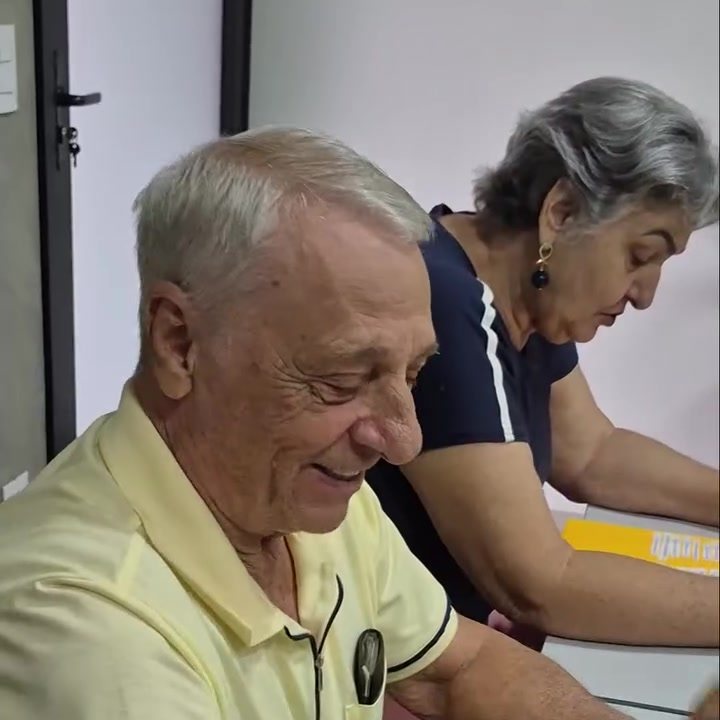 Aluno sorrindo enquanto faz a atividade em sala