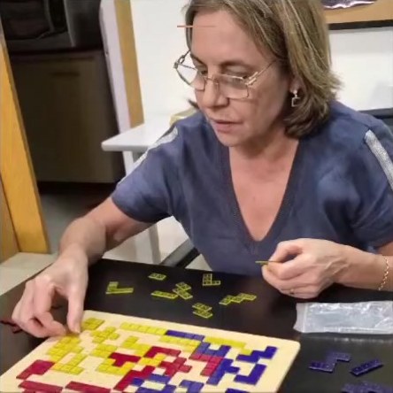 Aluna montando peças no tabuleiro do jogo Território
